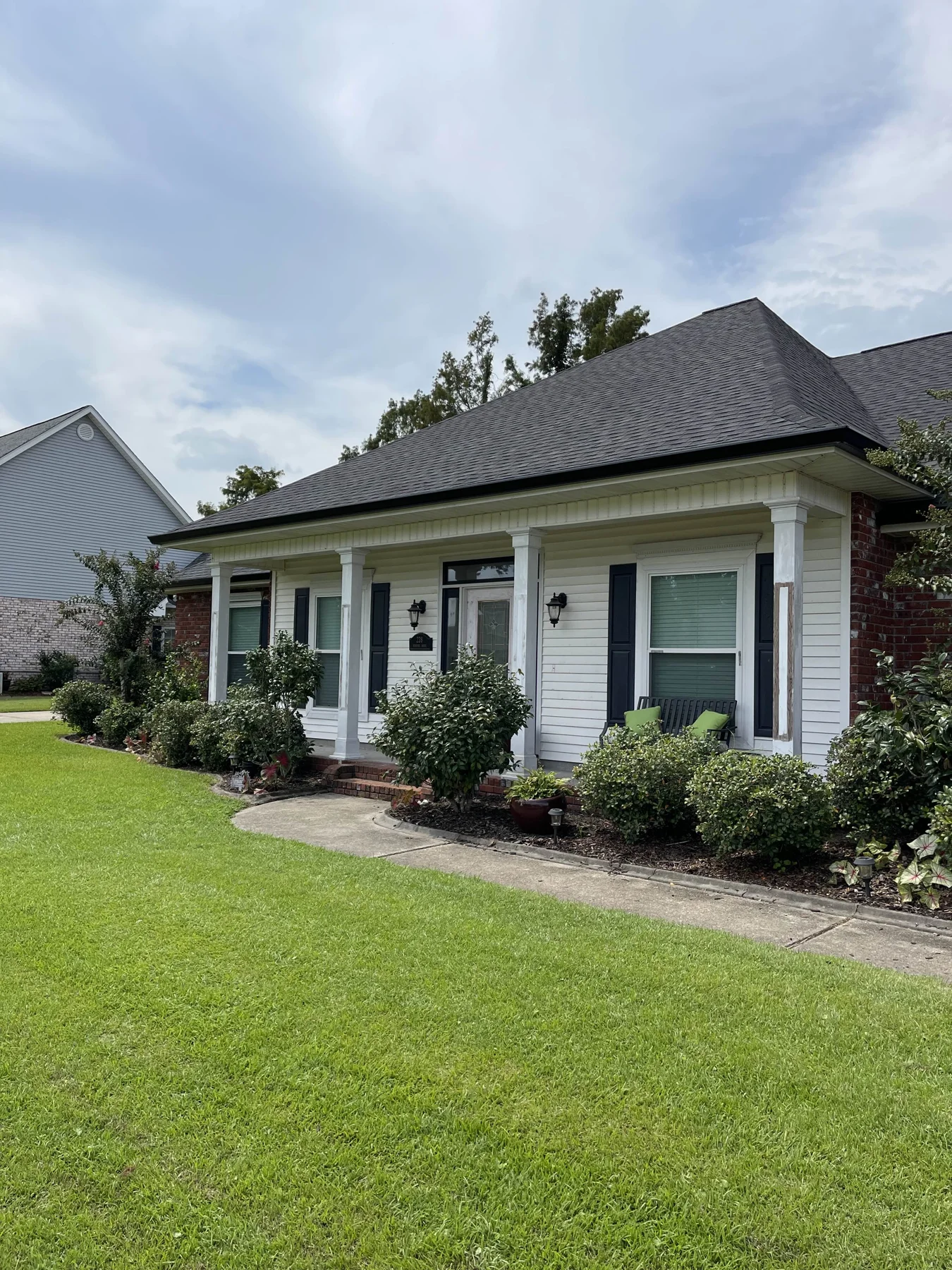 Gutter installation on a brick home with front porch