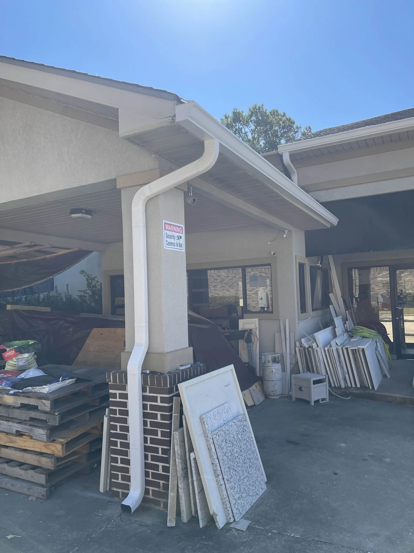 White downspout beside a covered patio