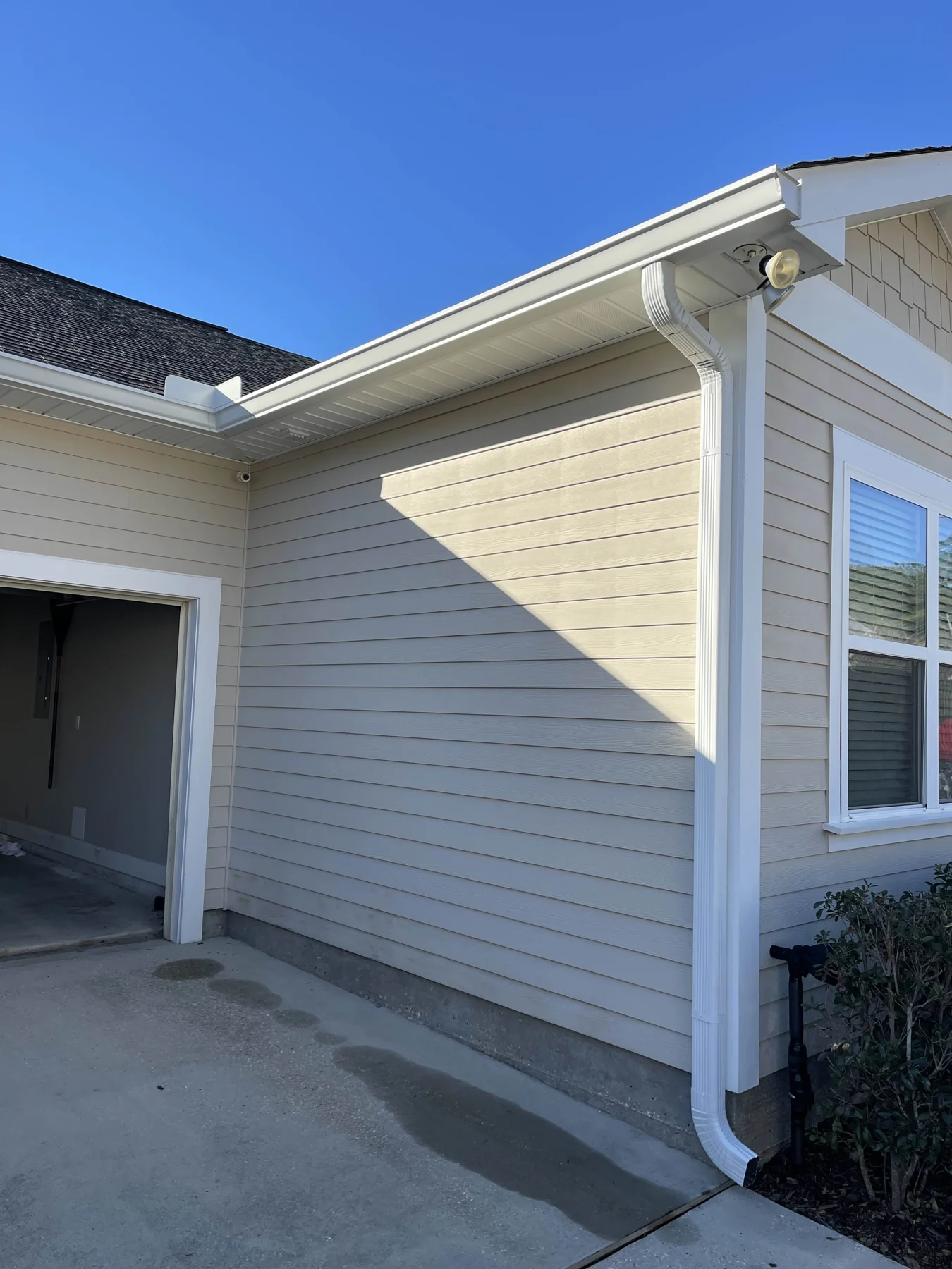 White gutter corner and downspout on siding