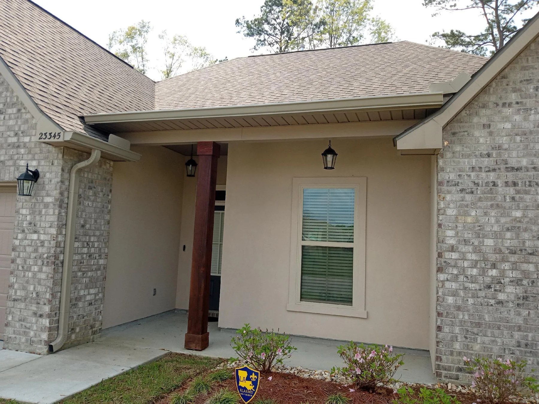Gutter outlet beside a covered entry