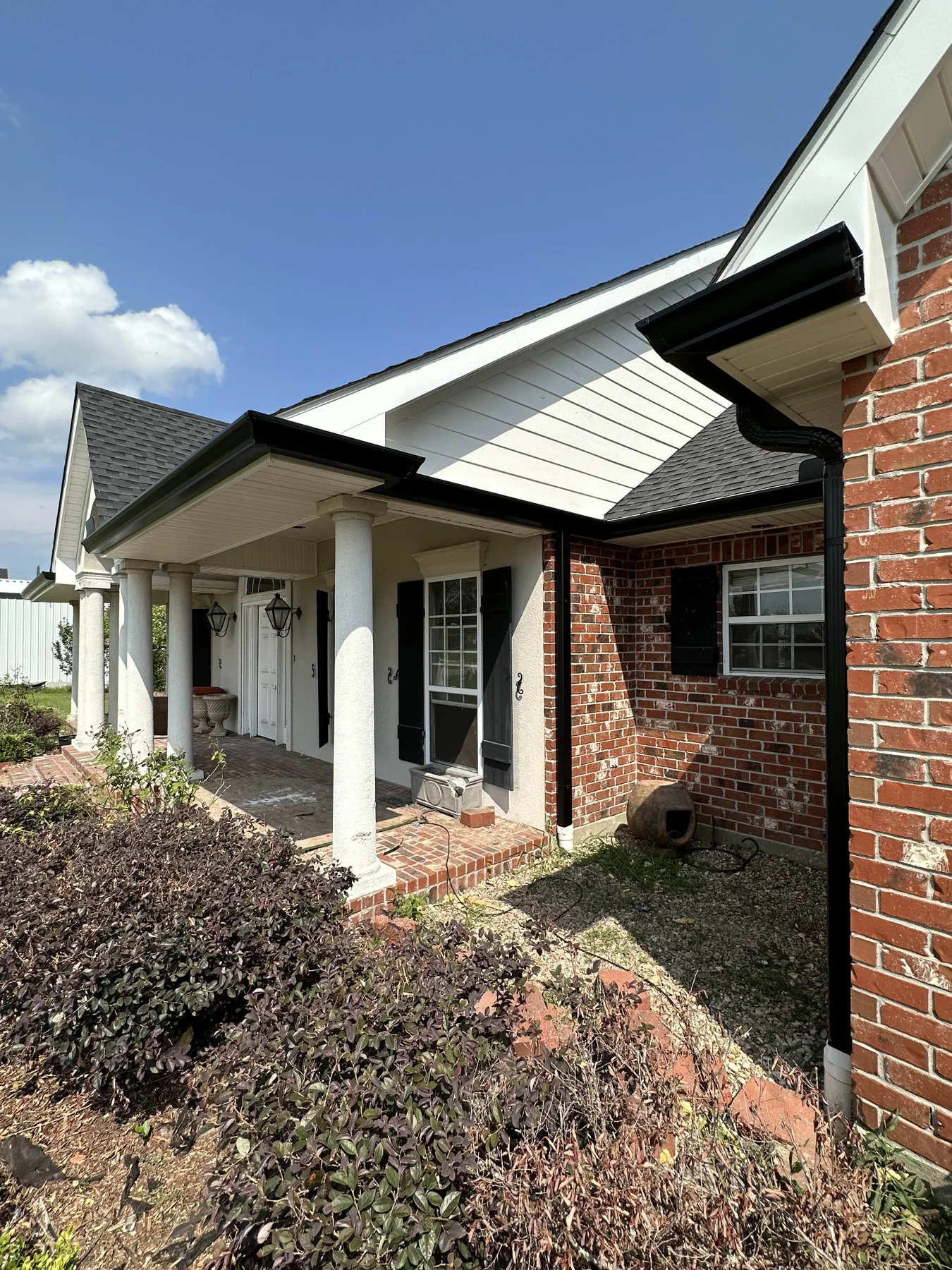 Dark gutters above a landscaped porch